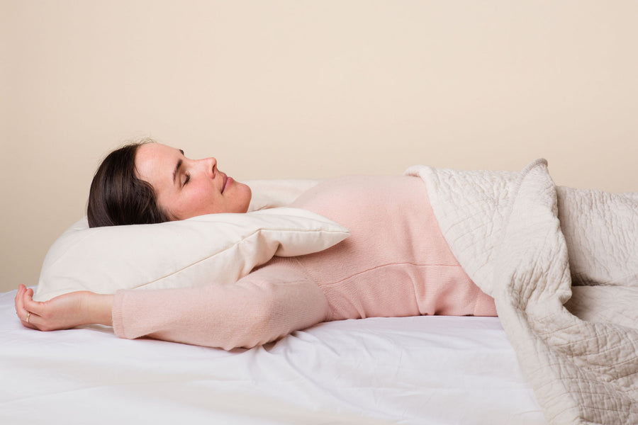 Woman on bed with ComfyCurve buckwheat pillow